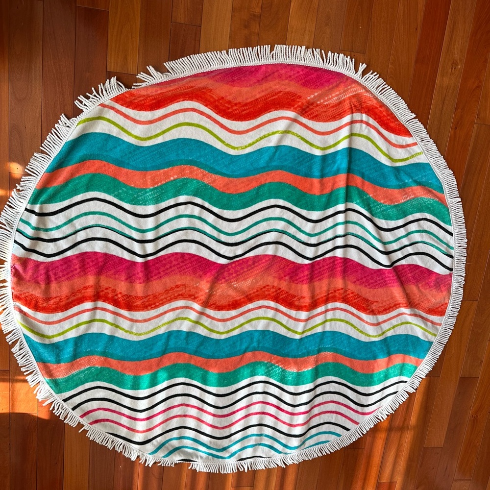 Chicos Wavy Striped Round Beach Towel with white fringe.